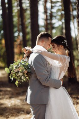 Ormanda kucaklaşan mutlu genç çiftler.