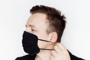 Stüdyoda maske takan genç bir adam. 