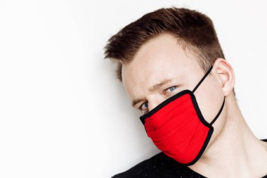 Stüdyoda maske takan genç bir adam. 