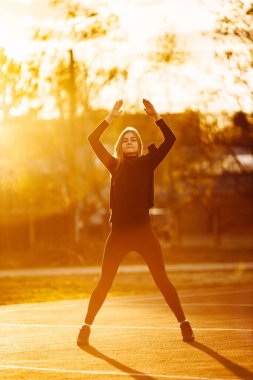 Park yerinde egzersiz yapan genç, zinde bir kadın.