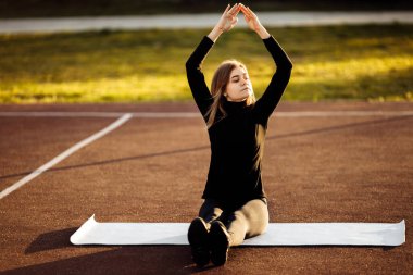 Park yerinde egzersiz yapan genç, zinde bir kadın.