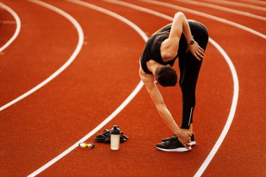 Delikanlı stadyumda egzersiz yapıyor. 