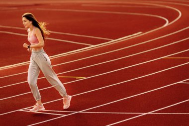 Stadyumda egzersiz yapan genç ve formda bir kadın. 