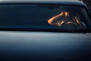 Arabada maske takan genç bir adam.