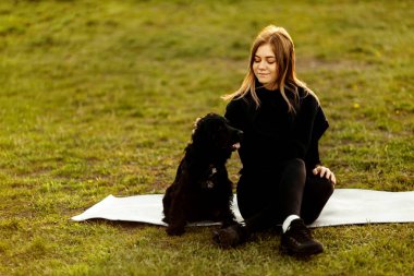 Parkta köpeği olan genç bir kadın. 