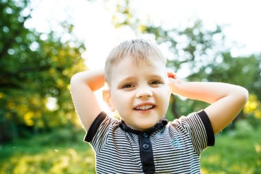 Dışarıda ormanda poz sarışın küçük çocuk portresi
