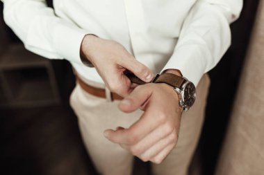 Adam onun kol saati zamanında kontrol