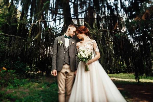Portrait of beautiful romantic couple in green forest. Wedding ceremony in nature.