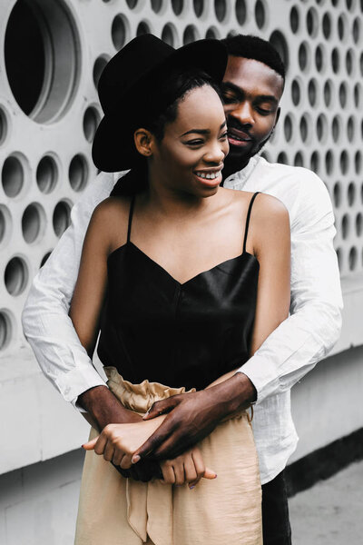 Portrait of a beautiful stylish African American couple hugging outdoors