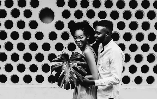 cheerful African American couple in fashion clothes on modern dots background.