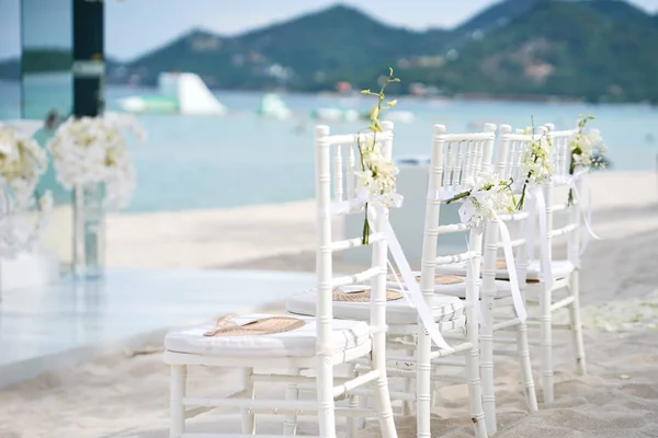 白色木舍威尔宴会椅上的婚礼排在沙滩上 扇子纪念品 典雅的风格 玫瑰花瓣锥 — 图库照片