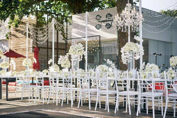 The wedding venue for reception dinner table decorated with white orchids, white roses, flowers, floral, white and clean theme on the Beach