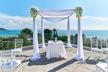 Wedding venue setting, Arch and altar decorated with roses, flowers, ocean background clipart