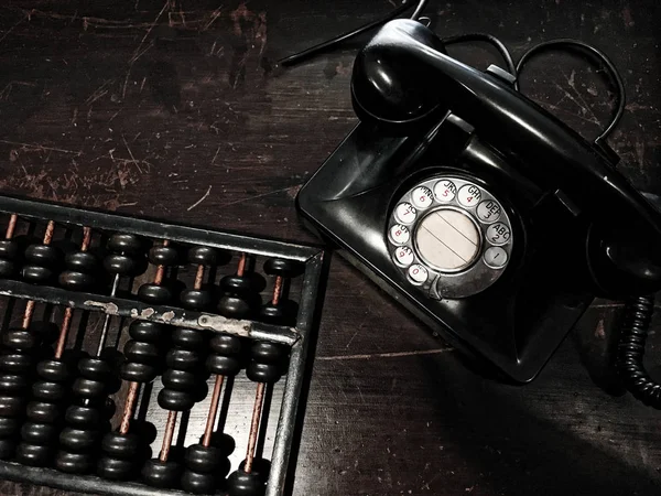 Teléfono de línea antigua y ábaco en la mesa de madera — Foto de Stock