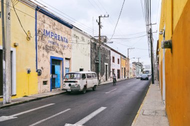 Merida / Yucatan, Meksika - 1 Haziran 2015: aksine parlak sarı renkli duvar ve mavi kapı Merida, Meksika eski bina infront otopark eski model araba