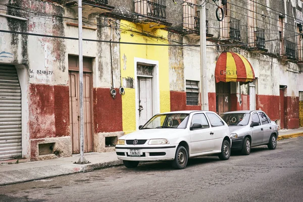 Merida / Yucatan, Meksika - 1 Haziran 2015: aksine parlak sarı renk eski bina infront otopark arabalar Duvar Merida, Meksika'da — Stok fotoğraf