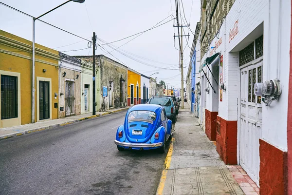 Merida / Yucatan, Meksika - 1 Haziran 2015: eski kırmızı ve sarı usee, Yucatan, Meksika içinde bina infront otopark eski model mavi araba — Stok fotoğraf