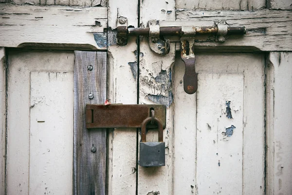 Old white door with rusty latch locked with steel key — Stock Photo, Image