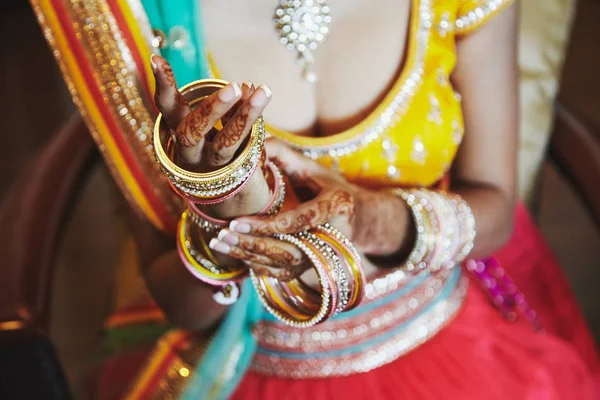 Noiva indiana usar saree colocando as pulseiras (pulseira) na mão com mehndi, close-up — Fotografia de Stock