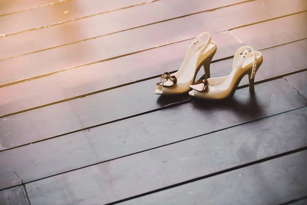Zapato mujer bomba marfil adornado con cepillo corazón en el suelo de madera con espacio — Foto de Stock
