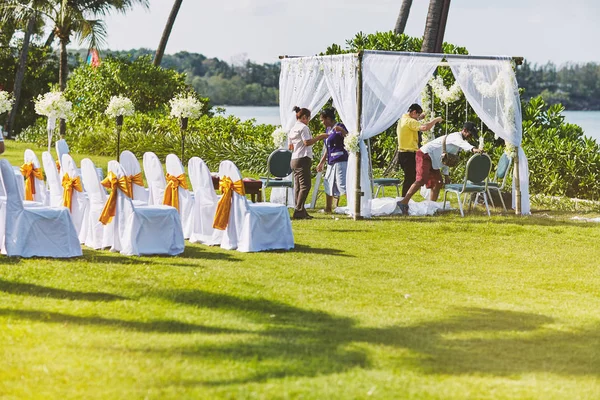 Samui Island, Tailandia - 2014 / 04 / 21: Personal trabajando y preparando el lugar de la boda en el campo de hierba cerca de la playa — Foto de Stock
