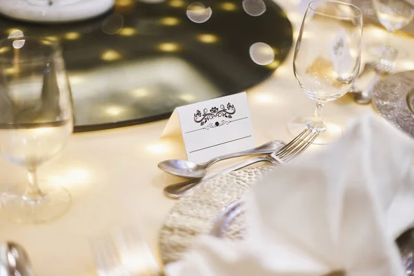 Mock up for white label with ornament art for name tag on the dinner table with bokeh and blurry foreground and background