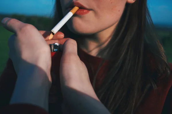 Das Mädchen Raucht Eine Zigarette Frauenhände Halten Feuerzeug Der Hand lizenzfreie Stockbilder