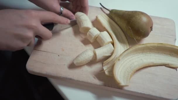 Девушка порезала кусочки банана — стоковое видео