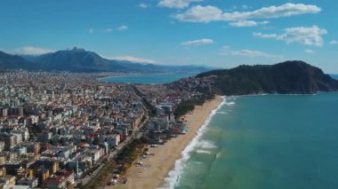 Alanya Türkiye 'nin havadan görünüşü. Güneşli bir hava ve tatil köyünde boş bir plaj. Deniz kıyısındaki konutlar.
