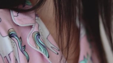 Yakasında pembe pijama tasması var. Kaliteli kumaşlı arka plan yavaş çekim videosu.