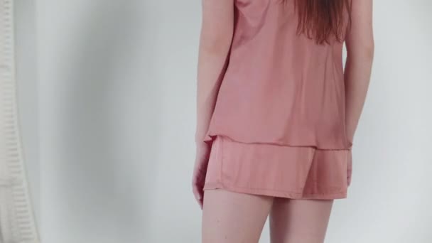 Rosa shorts närbild. Glad flicka dansar framför kameran, poserar i nya pyjamas på en vit bakgrund. — Stockvideo