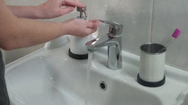 Kadın ellerini iyice yıkıyor, COVID-19 'da dezenfeksiyon için sıvı sabun kullanıyor. Koronavirüs karantinasında hijyen, mikropları öldürmek için el dezenfeksiyonu..