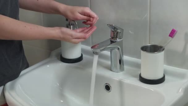 Kadın ellerini iyice yıkıyor, COVID-19 'da dezenfeksiyon için sıvı sabun kullanıyor. Koronavirüs karantinasında hijyen, mikropları öldürmek için el dezenfeksiyonu.. — Stok video