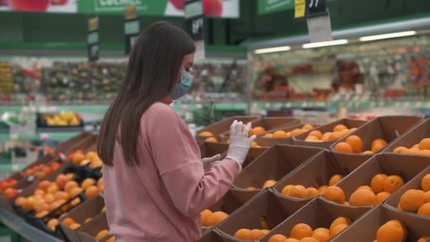 Muchacha Joven Hermosa Máscara Médica Escoge Las Naranjas Tienda Tienda — Vídeo de stock