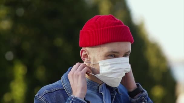 Jovem Com Chapéu Vermelho Coloca Uma Máscara Protetora — Vídeo de Stock