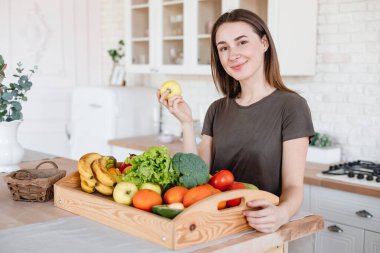 İnce kadın mutfakta elma tutuyor.