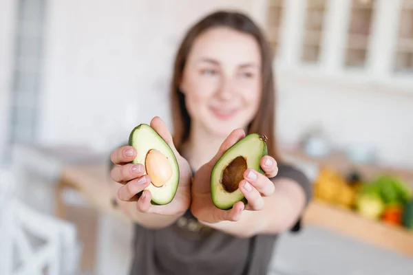 Girl Holds Cut Avocado Kitchen — Stock Photo, Image