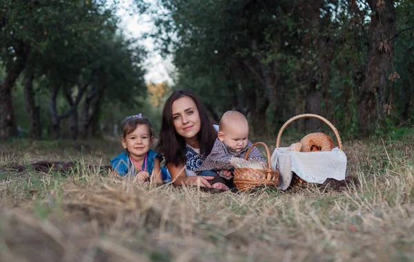 Beautiful mom and kids. Girl, boy and young mother lie on grass — Stock Photo, Image