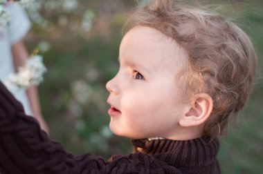 Yanında güzel bir çocuğun yüzü vardı. Beyaz tenli şık bir çocuğa kahverengi gözler ve beyaz bukleler. Bahar bahçesinde portre