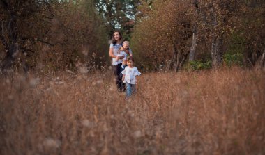 Beyaz bluzlu küçük bir kız annesinden kaçar ve güler. Dışarıdaki aile için eğlence zamanı. Şehirde akşam Sonbahar Bahçesi