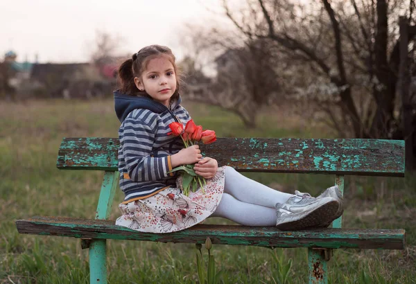 Een Schattig Meisje Met Bruine Ogen Rode Tulpen Haar Pennen Rechtenvrije Stockfoto's