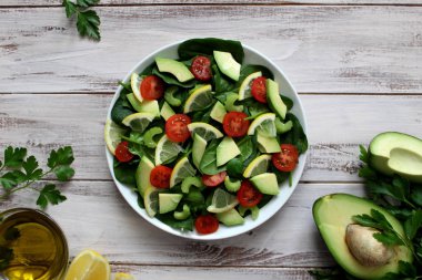Avokado ve plaka üzerinde sebze salatası. Üstten Görünüm. Vejetaryen ve vegan gıda.
