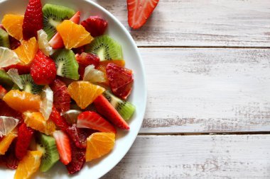 Sağlıklı taze meyve salatası ahşap arka plan üzerinde saçtan. Üstten Görünüm.