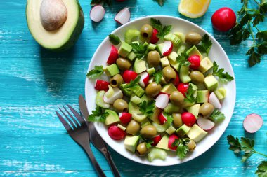 Sağlıklı avokado salatası, kereviz, çiğ ve zeytinli ahşap zemin. Kopyalama alanı olan üst görünüm. Sağlıklı yemek..