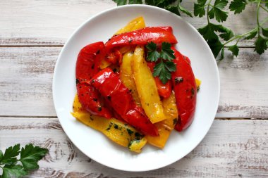 Kavrulmuş sarı ve kırmızı biber beyaz bir tabak içinde. Vejetaryen ve vegan gıda. Üstten Görünüm.