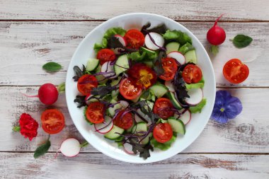 Taze sebze salatası: domates, marul, salatalık ve çiğ arkaplan. Kopyalama alanı olan üst görünüm.