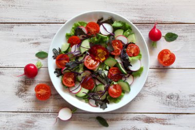 Taze sebze salatası: domates, marul, salatalık ve çiğ arkaplan. Kopyalama alanı olan üst görünüm.