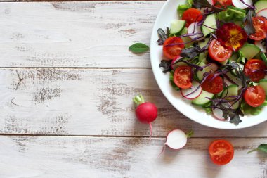 Taze sebze salatası: domates, marul, salatalık ve çiğ arkaplan. Kopyalama alanı olan üst görünüm.