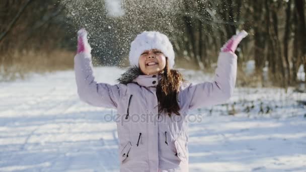 Petite fille jetant une poignée de neige dans les airs — Video