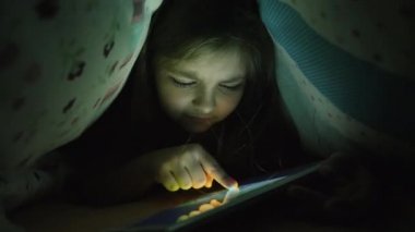 Bir kız on yıllık bir tablet geceleri kullanır.